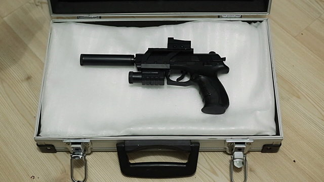 Male hands open suitcase with gun