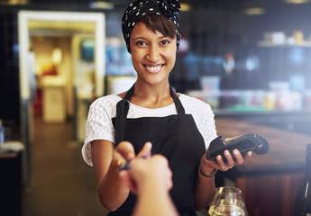 Smiling waitress taking a credit card - Powered by Adobe