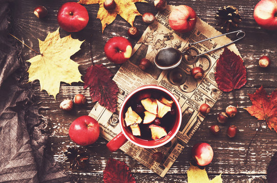 Cup of warming tea with apple and cranberry and woolen scarf