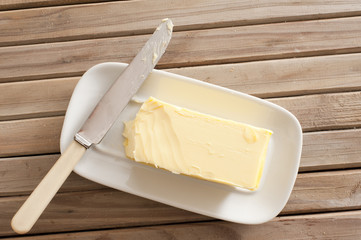 Pat of fresh farm butter on a dish - obrazy, fototapety, plakaty