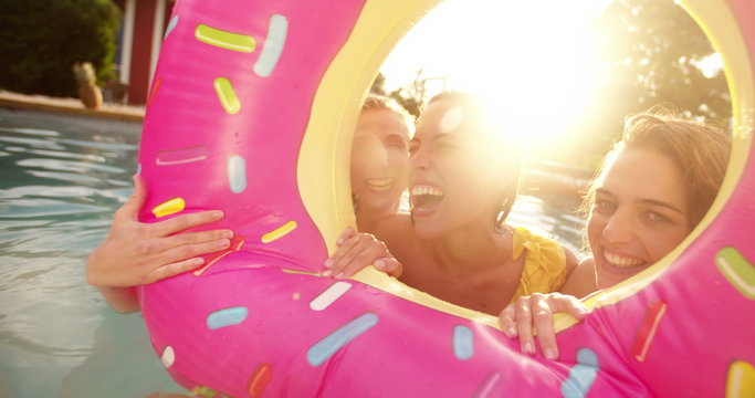 Girls making laughing and having fun in a pool on summer afternoon