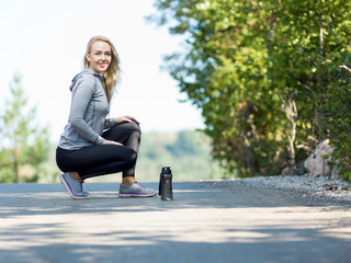 Young woman stretching before running in the early evening