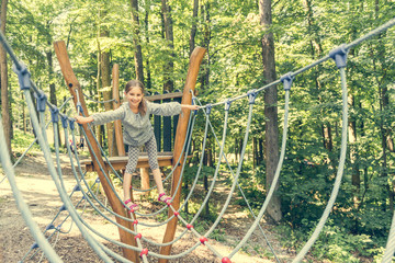 Fototapeta premium happy little girl in a rope park 