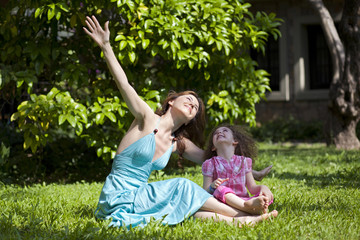 Fototapeta premium Mother and daughter are enjoying on grass at park