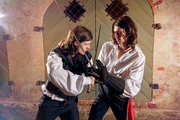 Men fighting with swords at old town street