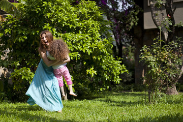 Mother and daughter are enjoying on grass at park