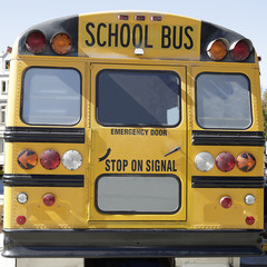 Rear view of a traditional yellow school bus on the street