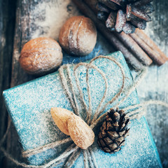 Christmas Holiday Box with Linen Cord, Decorative Snow, Nuts  on Wooden Background. Toned image. Vintage