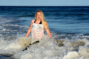 Fototapeta premium Von der Welle überrascht, Junge Frau im Meer