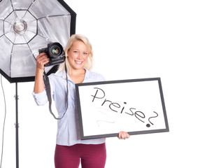 Fotografin hält eine Preistafel in der Hand und lächelt