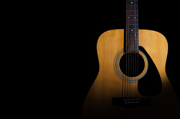 Fototapeta na wymiar Acoustic guitar on a black background. Close-up. Background for