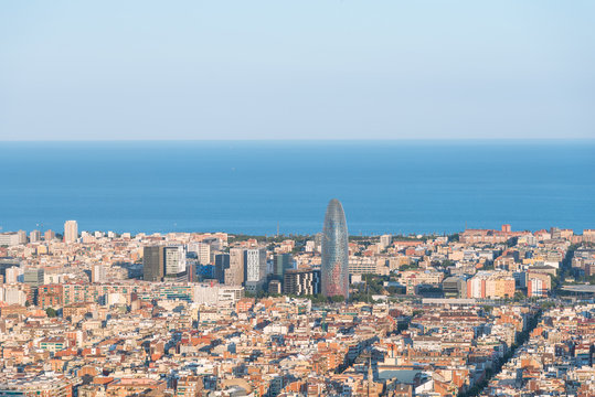 The Torre Agbar in the Poblenou district of Barcelona. The Tower is surrounded by other skyscrapers. The Torre Agbar is intended to recall the shape of a geyser rising into the air