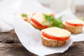 Little Snacks with Bread, Tomato, Cheese on Wooden Table