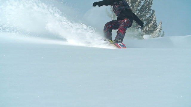 Slow motion shot of skilled snowboarder enjoying freeride on fresh fallen snow