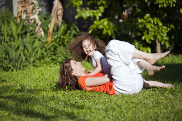 Mother and daughter are enjoying on grass at park