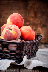 Simple Composition with Peaches in Basket on the Wooden background