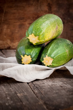 Simple Composition with Vegetable Marrow on Napkin. Wooden background