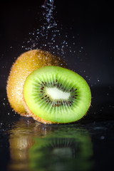 kiwi fruit with water spray on black background