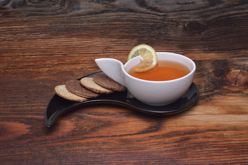Cup of tea and crackers on wood