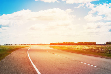 Rural Road with Turn and Clouds on Sky