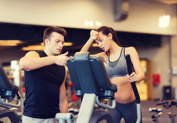 woman with trainer exercising on stepper in gym