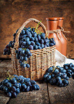 Blue Grapes in Country Basket on Wooden Background