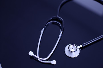 Stethoscope on black, reflective background