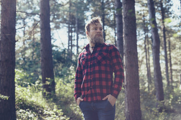 Man with beard in pine tree forest.