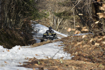 man driving a quad bike in the winter field