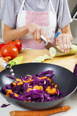 Hands cutting cucumber. Preparation for salad or wok.Healthy vegetables