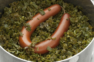 Cooking pot with cooked curly kale and sausage