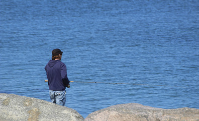 Fototapeta na wymiar Young man at the shore fishing