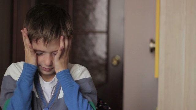 Boy playing computer at home headache