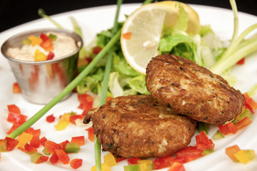 crab cakes with dipping sauce, with pepper garnishes, with restaurant appetizer