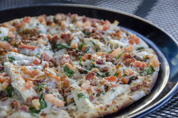 flat bread pizza with grilled chicken, bacon and vegetables