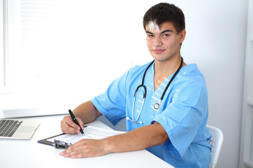 Portrait of unknown male surgeon doctor holding his stethoscope, crossed arms