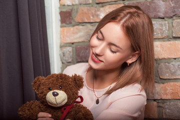 Young girl in a rose dress with bear toy. Studio photo