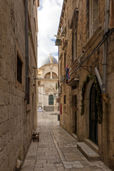 Fototapeta na wymiar Narrow and empty alley and Church of Saint Blaise (Blasius) at the Old Town in Dubrovnik, Croatia.