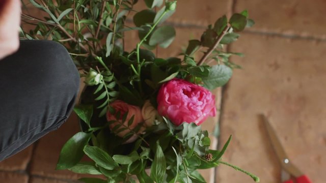 Florist making a red peonies