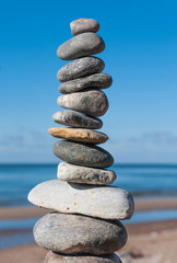 Fototapeta na wymiar Stones pyramid on beach symbolizing harmony,balance