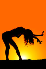 silhouette woman in bikini stand bend forward hands out