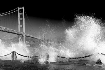 Papier Peint photo Lavable San Francisco Golden Gate Bridge. Wild huge waves crashing. Dramatic black and white image of stormy night.