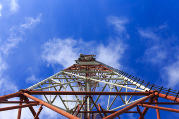 bottom view of a telecommunications tower. red and white telecommunication tower against blue sky, bottom view
