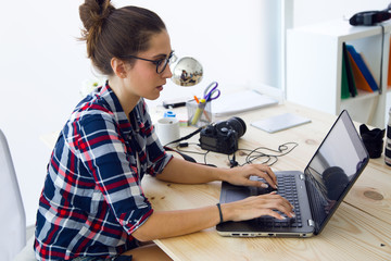 Young businesswoman working in her office with laptop.