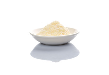 Grated cheese in a white bowl over white background