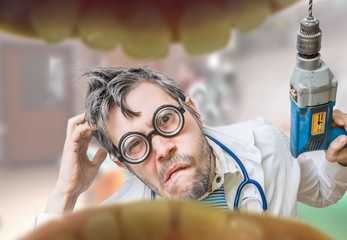 Uncertain and unsure crazy dentist doctor looks into mouth and wants to drill tooth decay. - obrazy, fototapety, plakaty