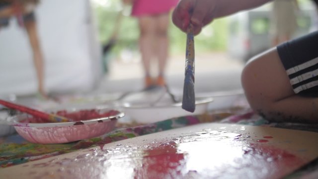 Slow motion of a kid hand painting with brush