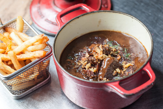 Belgian beef stew 'carbonades flamandes' in a vintage pot with French fries