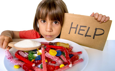 little child eating sweet sugar in candy dish holding sugar spoo