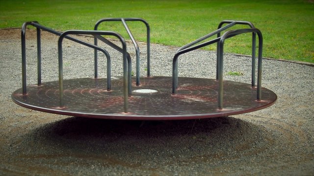 Sad empty merry go round spinning in a playground, 4K, Ultra HD